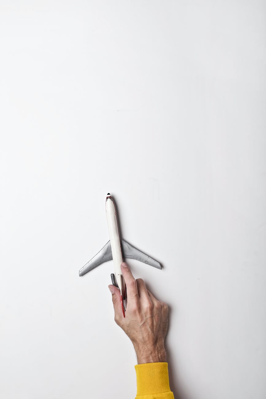 male hand with white toy plane